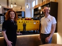 Zwei Personen neben einer gelben Rancilio-Kaffeemaschine in einem Café.