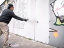 Mann sprüht Graffiti auf Wand mit Schrift 'Hip Hop Kultur'.