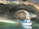 Bootsfahrt in einer beleuchteten Höhle mit Wasser.