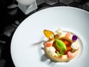 Elegantes Dessert auf weissem Teller mit kleinen Dekorationen.
