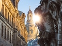 Sonne hinter Dom in einer alten Stadt, mit Barockarchitektur.