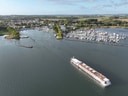 Luftaufnahme eines Flusses mit Kreuzfahrtschiff und Hafen.