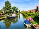 Malersicher Kanal mit Booten und Häusern am Ufer.