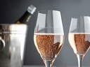 Zwei Gläser mit Sekt, Flasche im Eiskübel.