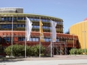 Buntes Gebäude mit Fahnen und blauem Himmel im Hintergrund.