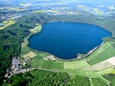 Luftaufnahme eines vulkanischen Sees in grüner Landschaft.