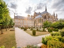 Garten mit Bäumen und historischer Kathedrale im Hintergrund.