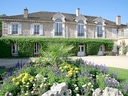 Historisches Steinhaus mit Garten voller Blumen.