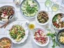 Verschiedene frische Salate und Dips auf einem Tisch.