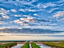 Küste mit Wolkenhimmel und Wattlandschaft.