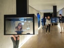 Menschen betrachten interaktive Ausstellung in modernem Museumsgang.