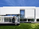 Moderne weisse Fassade eines grossen Gebäudes mit Glasfront.