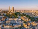 Panorama von Paris mit der Basilika Sacré-Cœur bei Sonnenuntergang.