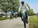Gruppe von Radfahrern auf einem Weg entlang eines Flusses.