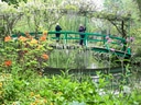 Menschen auf grüner Brücke im blühenden Garten.