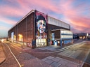 Straat Museum in Amsterdam mit bunter Fassadenkunst bei Sonnenuntergang.