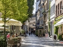 Belebte Fussgängerzone mit Cafés und Geschäften.
