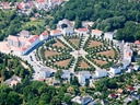 Luftaufnahme eines kreisförmigen Platzes mit Bäumen und Gebäuden.