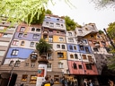 Buntes, ungewöhnlich gestaltetes Gebäude mit Bäumen auf dem Dach.