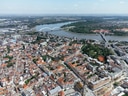 Luftaufnahme einer Stadt mit Fluss und Brücke im Hintergrund.