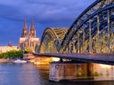 Hohenzollernbrücke und Dom in Köln im Abendlicht.