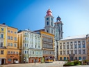 Farbenfrohe historische Gebäude und Kirche auf einem Platz.