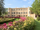 Historisches Gebäude mit gepflegtem Rosengarten.