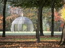 Kuppelförmige Skulptur im Park mit Herbstbäumen.