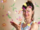 Frau wirft Blütenblätter aus Korb.