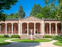 Historisches Gebäude mit Säulen und Büste im Garten.
