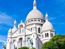 Weisse Basilika Sacré-Cœur in Paris vor blauem Himmel.