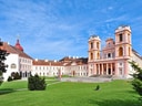 Barockkloster mit weitläufigem Rasen und blauem Himmel.