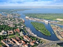 Luftaufnahme einer Stadt mit Fluss und Hafenanlagen.