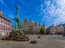 Grosser Platz mit Brabo-Statue und historischen Gebäuden unter blauem Himmel.