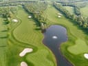 Luftaufnahme eines Golfplatzes mit Teich und Bunkern.