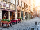 Strassencafé in malerischer Gasse mit Fachwerkhäusern.