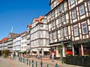 Strassenszene mit Fachwerkhäusern und Menschen, die spazieren gehen.
