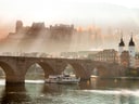 Heidelberger Schloss über Fluss und Alte Brücke im Morgenlicht.