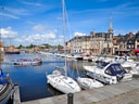 Hafen mit Segelbooten und historischer Architektur im Hintergrund.