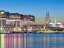 Abendansicht von Köln mit Kranhäusern und Dom.