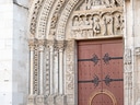 Person fotografiert detailliertes Bogentor einer Kathedrale.