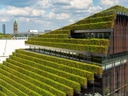 Gebäude mit terrassenförmigen grünen Pflanzen auf dem Dach in einer Stadt.