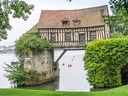 Historisches Fachwerkhaus auf Brücke über Fluss.