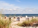 Strandkörbe am Sandstrand mit Meerblick.