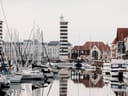 Yachthafen mit Booten und einem Leuchtturm.
