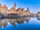 Historische Gebäude spiegeln sich im Wasser in Gent.