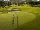 Zwei Golfer auf einem grünen Golfplatz.