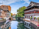 Fachwerkhäuser am Flussufer in malerischem Viertel.
