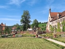 Schlossgarten mit Statuen und historischem Gebäude.