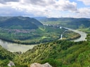 Panoramablick auf die Donau und grüne Hügel.